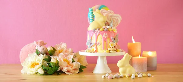 Bolo de gotejamento de terra de doces de Páscoa decorado com pirulitos e coelho branco . — Fotografia de Stock