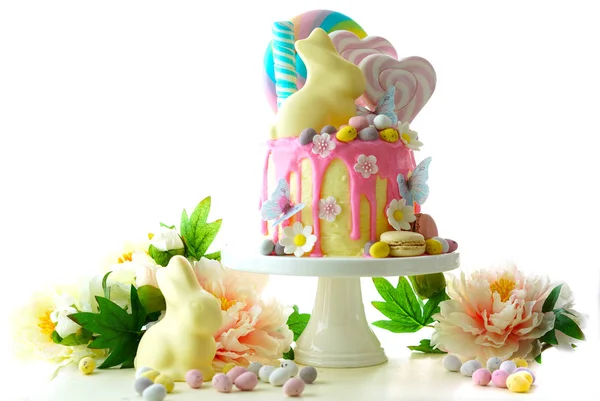 Easter candy land drip cake decorated with lollipops and white bunny. — Stock Photo, Image