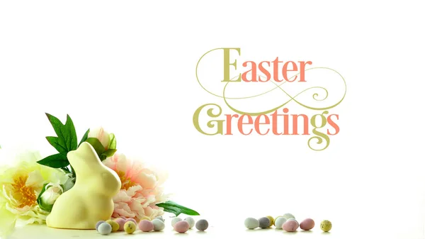 Easter background with white chocolate bunny and spring flowers border and text. — Stock Photo, Image