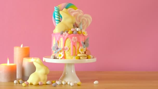 Páscoa candyland gotejamento bolo com coelho de chocolate branco em configuração de mesa de festa . — Vídeo de Stock