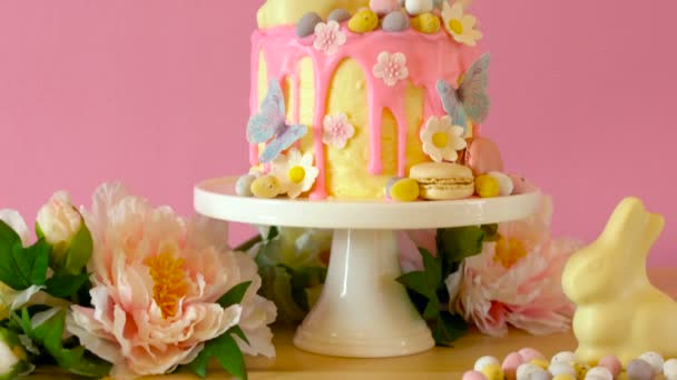 Velikonoční candyland odkapávat dort s bílé čokoládové bunny v stranu prostírání. — Stock video