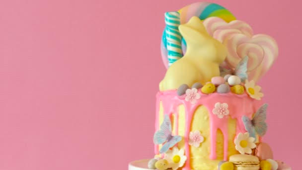 Gâteau goutte à goutte aux bonbons de Pâques avec lapin en chocolat blanc dans le cadre de la table de fête . — Video
