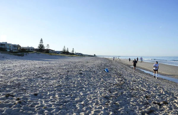 Early morning joggers and people exercising on wide open sandy beach. — Stock Photo, Image