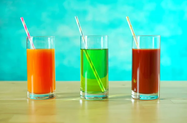 Fresh orange, apple and tomato juices in glasses with paper straws. — Stock Photo, Image