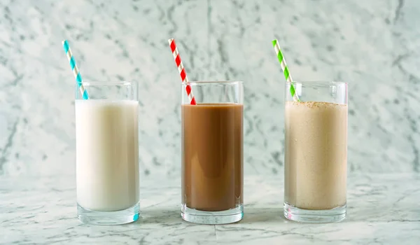 Nutritious vanilla, chocolate and cinnamon almond milk in glasses. — Stock Photo, Image