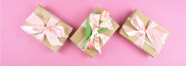 Presentes embrulhados em papel kraft e fitas rosa overhead flatlay . — Fotografia de Stock