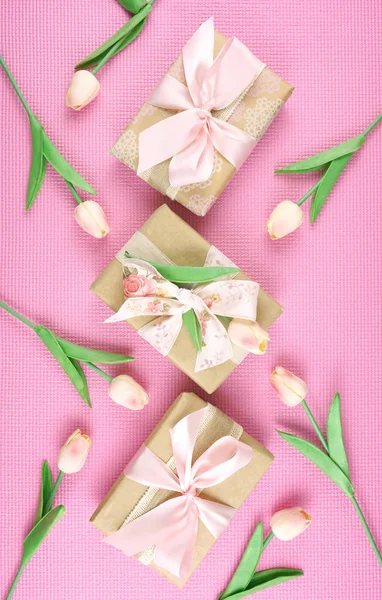 Geschenken verpakt in Kraft papier en roze linten overhead flatlay. — Stockfoto