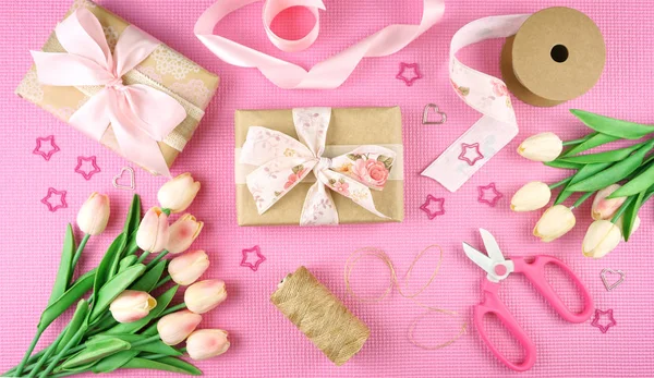 Geschenken verpakt in Kraft papier en roze linten overhead flatlay. — Stockfoto