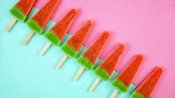 Görögdinnye ízesített nyári fagylalt popsicles a rózsaszín és kék háttér. — Stock Fotó