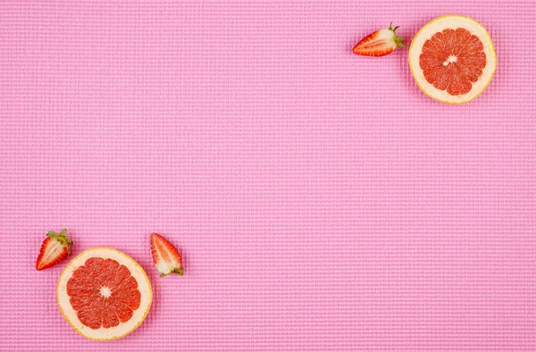 Летний фон с рубиновым грейпфрутом на розовом фоне, с копировальным пространством . — стоковое фото