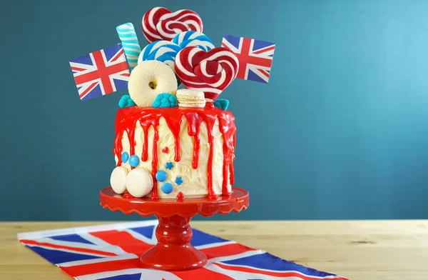 UK candyland drip cake with red white and blue decorations, lollipops and flags. — Stock Photo, Image