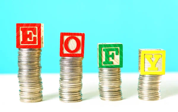 End of Financial Year and savings concept stacking coins with building blocks. — Stock Photo, Image