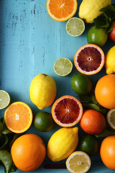 Mixed colorful citrus fruit on blue wood table. — Stock Photo, Image