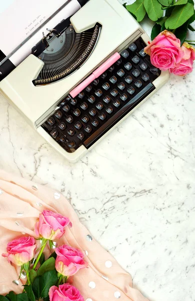 Romantic vintage writing scene with old typewriter overhead on marble table.