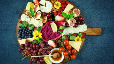 Ahşap tahta üzerinde peynir ve meyve charcuterie tatlı otlatma tabağı.