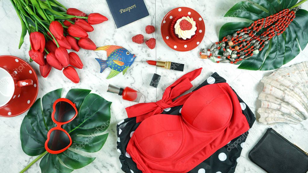 Summer vacation concept flatlay with red feminine accessories.
