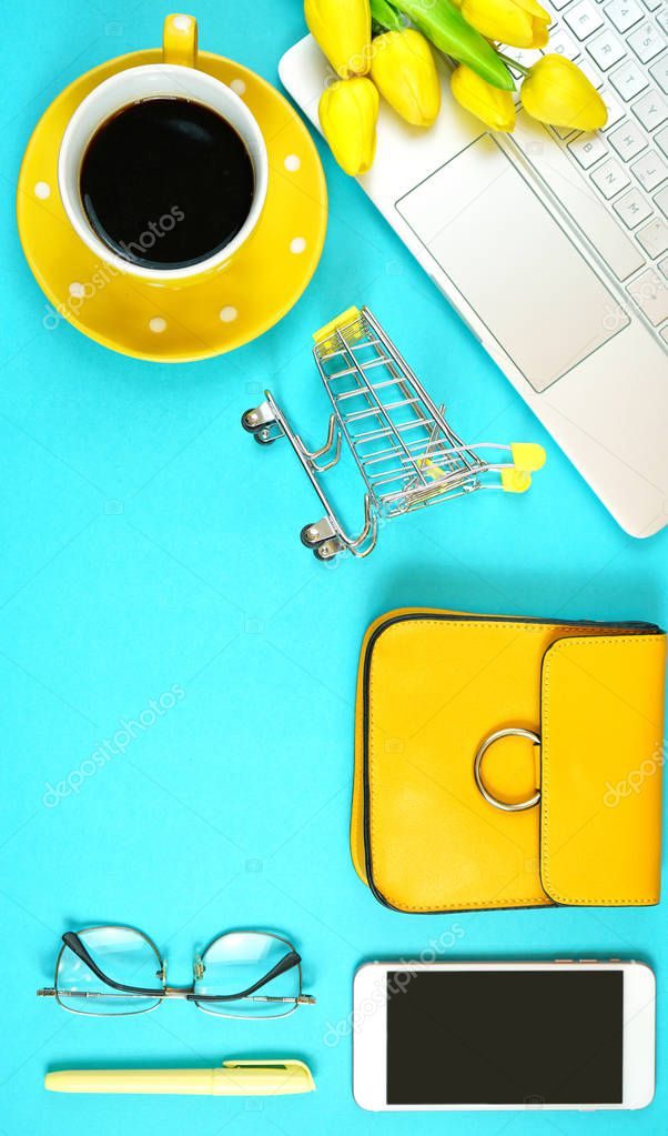 On-line shopping concept flatlay with shopping cart and accessories.