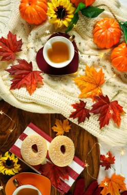 Sonbahar Sonbahar tema rahat kazak, simit ve bitkisel çay bardak ile flatlay.