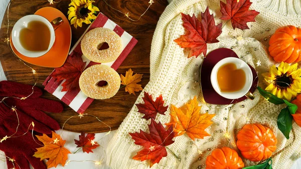 Осенний осенний тематический уголок с уютным свитером, бубликами и чашками травяного чая . — стоковое фото