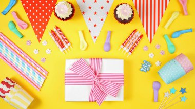 Renkli doğum günü partisi düz sarı arka plan üzerinde yatıyordu.