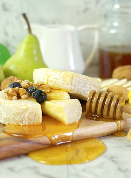 Queijo camembert e brie com mel, frutas e nozes . — Fotografia de Stock