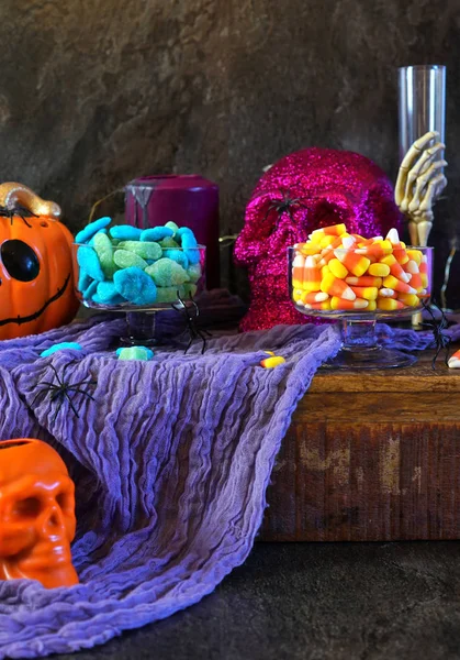 Halloween party table with candy, pumpkins and skeleton candles. — Stock Photo, Image