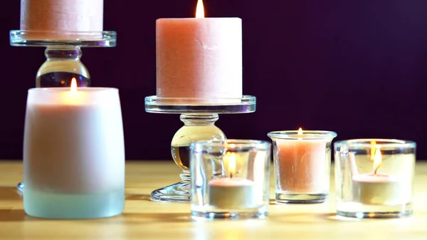 Aromatherapie samenstelling met roze kaarsen op tafel tegen paarse achtergrond — Stockfoto