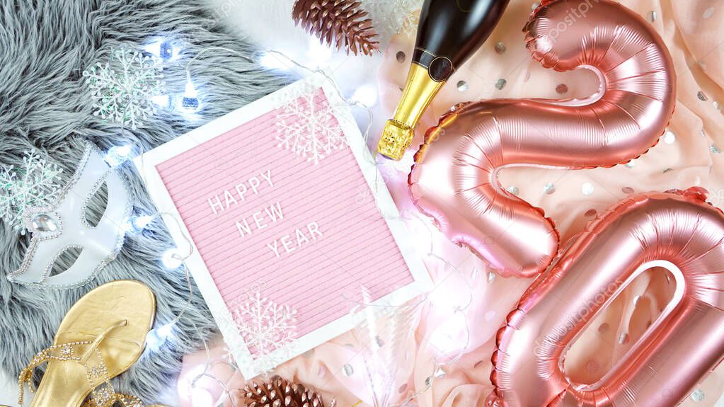 Happy New Year hygge style flatlay with rose gold balloons and letter board.