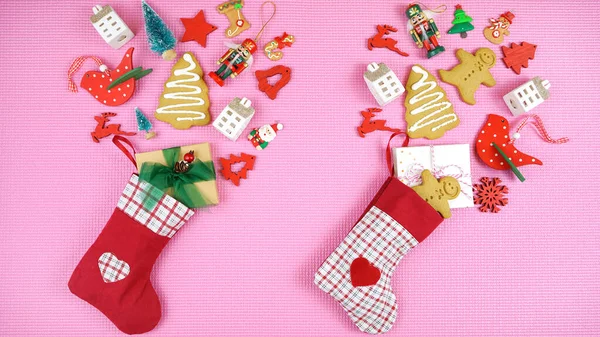 Weihnachtskonzept mit Strümpfen gefüllt mit Geschenken auf rosa Hintergrund. — Stockfoto