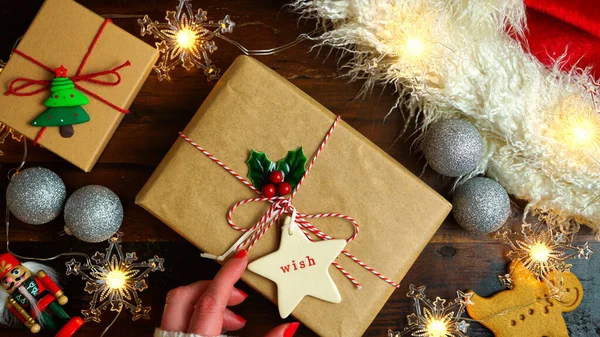 Περιτύλιγμα χριστουγεννιάτικα δώρα διακοπών σε σκούρο ξύλινο τραπέζι, νύχτα επίπεδη θέσει. — Φωτογραφία Αρχείου