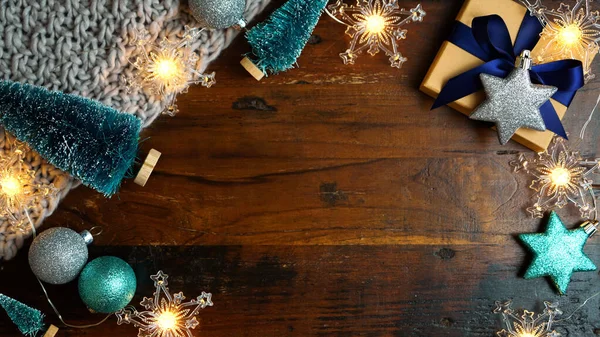 Wrapping Christmas holiday blue gifts on dark wood table, nightime flat lay. — Stock Photo, Image