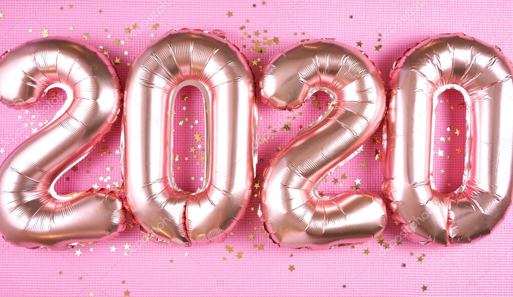 Happy New Years Eve rose gold foil 2020 metallic balloons on pink background.