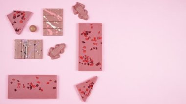 Yakut çikolata seçimi düz pembe arka plan üzerinde yatıyordu stop motion animasyonu.