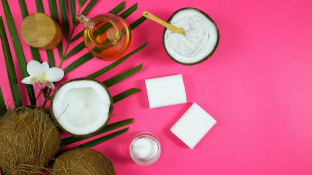 Coconut cosmetics with soaps, moisturizers, beauty products on pink background. — Stock Video