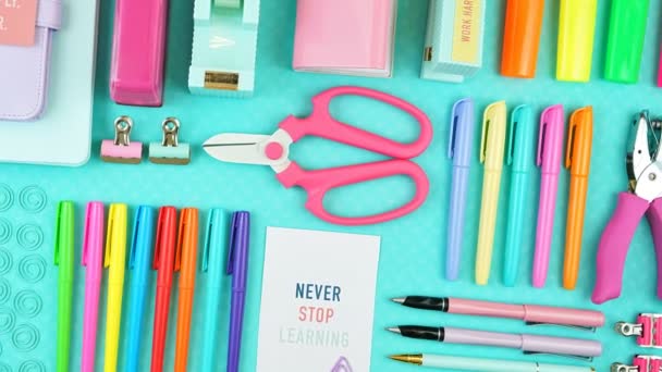 Voltar para a escola ou espaço de trabalho artigos de papelaria coloridos overhead flatlay . — Vídeo de Stock