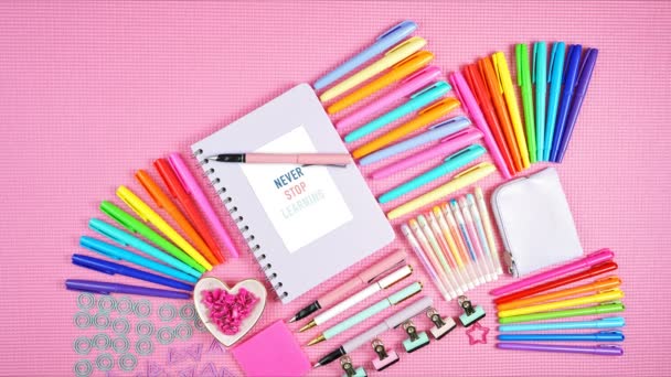 Torna a scuola o all'area di lavoro cancelleria colorata su movimento stop flatlay rosa . — Video Stock