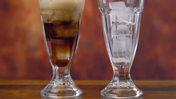 Verter refresco de cola sobre hielo en vasos altos de café . — Vídeo de stock
