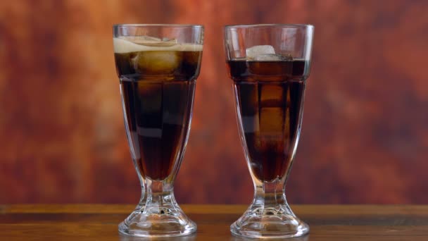 Verter refresco de cola sobre hielo en vasos altos de café . — Vídeo de stock