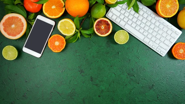 Citrusvruchten op getextureerde groene achtergrond werkruimte blog held header platte lay. — Stockfoto