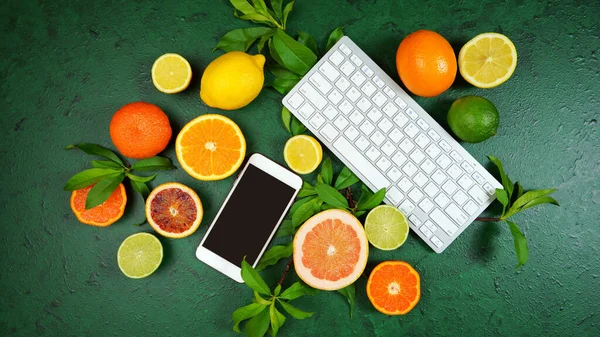 Citrus fruit on textured green background workspace blog hero header flat lay. — Stock Photo, Image