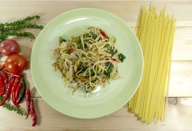 Baharatlı domuz sarı çizgili ahşap zemin, sahne dekorasyonu ile taze biber kırmızı, yeşil bir tabak kızarmış spagetti domates, üstten görünüm, yakın çekim