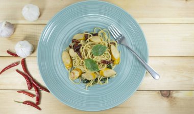 Spagetti yemek bule bir ahşap zemin tablo sahne dekorasyon kurutulmuş sosis biber ile sarımsak, kırmızı biber, gıda kavramı kaşık, metniniz için kopya alanı görünümüyle Top