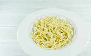 Spagetti sarı İtalyan makarna satır bir tabak Beyaz ahşap zemin tablo üzerinde metniniz için kopya alanı ile açık görünüm