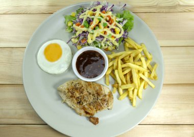 tavuk biftek gri çanak ve kızarmış patates üzerinde ahşap masa dekorasyon baharatlı sos domates, üstten görünüm ile sahne. Kopya alanı.