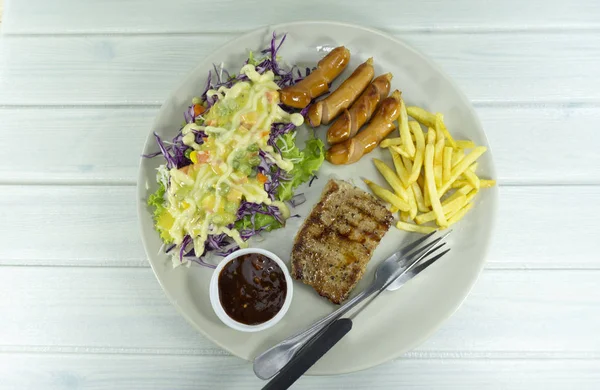 돼지고기 스테이크와 샐러드 자주색 평면도 접시에 소시지 — 스톡 사진