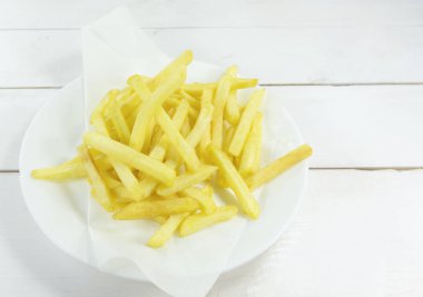 Patates kızartma ahşap zemin zemin üzerine beyaz bir tabak içinde en iyi görünümü Kapat.