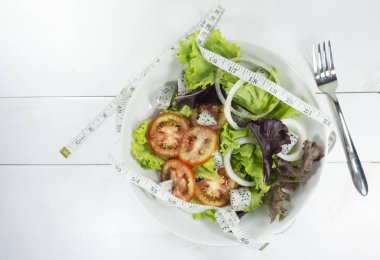 Diyet, sağlıklı beslenme, gıda ve kaybı kavramı tartmak - yeşil salata kadar yakın ve teyp, çatalı ölçme kat arka plan ağaç, görünümü top. Kopya alanı.