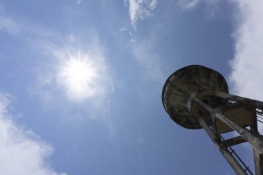 Su tankı inşaat parlak mavi gökyüzü durağındayım beyaz bulutlar zemin, metniniz için kopya alanı üzerine eski çimento