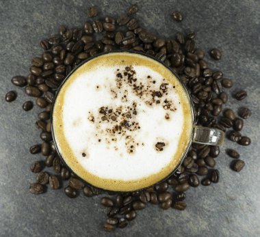 Kahve fasulye ve taş zemine arka plan üzerinde kahve Cappuccino cam