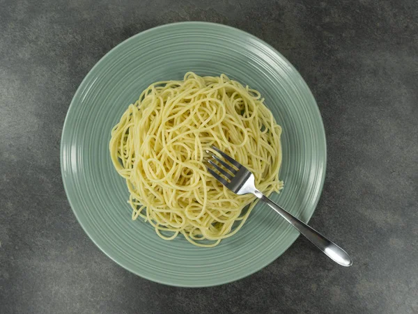 Spaghetti line yellow in a plate on a stone floor table,Top view, Copy space Close up